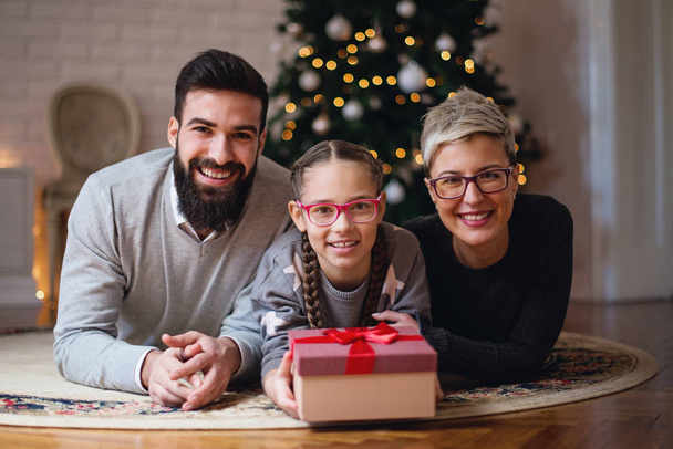 Família reunida em torno de uma árvore de Natal; pai, filha e mãe
  - Foto, Imagem