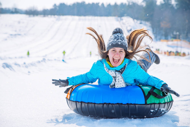 joven sonriente chica paseo trineo nieve tubing colina invierno actividad concepto
 - Foto, Imagen