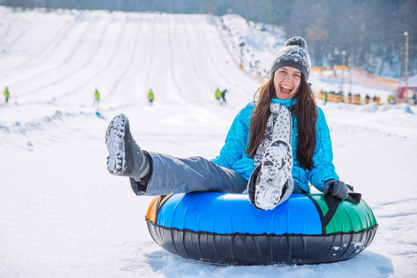 młody uśmiechnięta dziewczyna jeździć sanie śnieg rury wzgórze zima działalność koncepcja - Zdjęcie, obraz