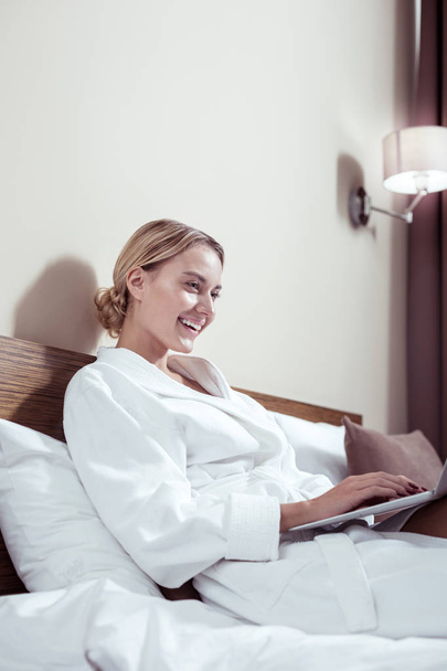 Businesswoman lying in bed in hotel room before business meeting - Фото, изображение