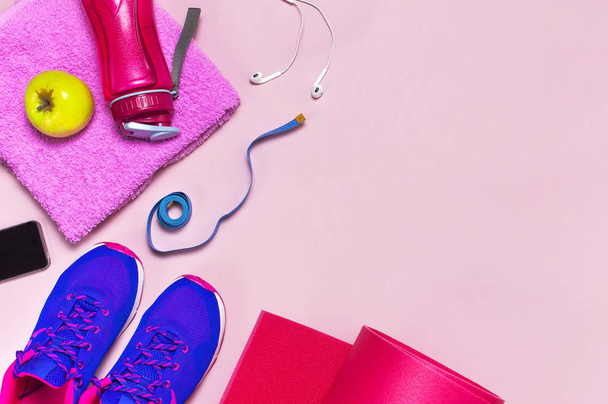 Fitness konsepti Ultra violetti vaaleanpunainen naisten lenkkarit, vesipullo, jooga matto, pyyhe, älypuhelin, kuulokkeet, omena pastelli vaaleanpunainen tausta tasainen lay top näkymä. Urheilu kengät Fitness käsite
 - Valokuva, kuva