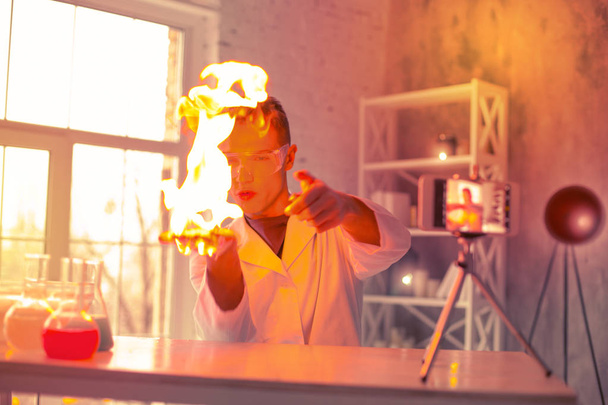 Curious experimenter causing fire on his palm - Foto, immagini