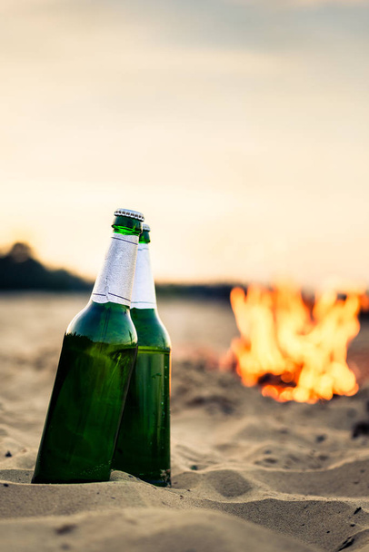 Пляшки зеленого пива на пляжі
 - Фото, зображення