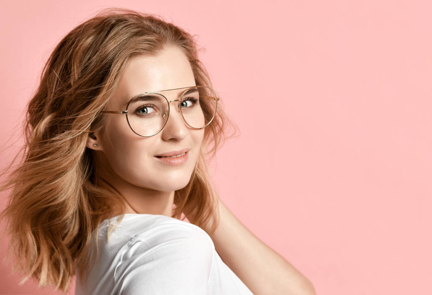 Beautiful woman in white t-shirt and modern glasses posing on pink - Zdjęcie, obraz