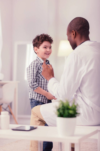 Feliz chico positivo hablando con su médico
 - Foto, imagen