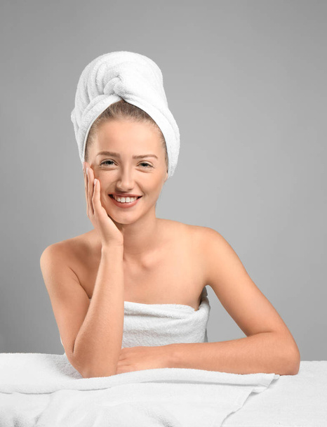 Mooie jonge vrouw na douche op grijze achtergrond - Foto, afbeelding