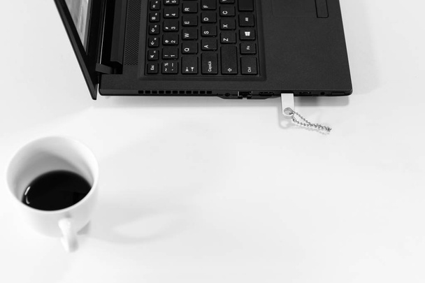 Top view of usb drive on laptop and cup of coffee in black and white background - Photo, Image