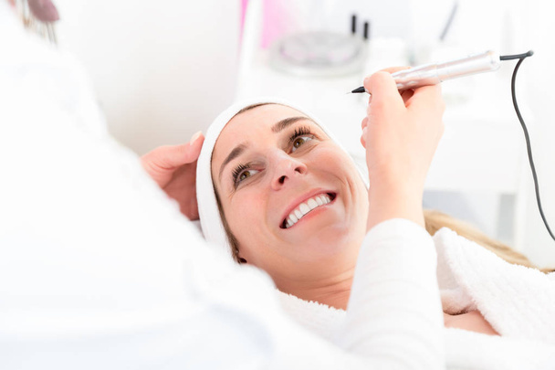 Smiling woman in beauty salon for treatment - Photo, Image