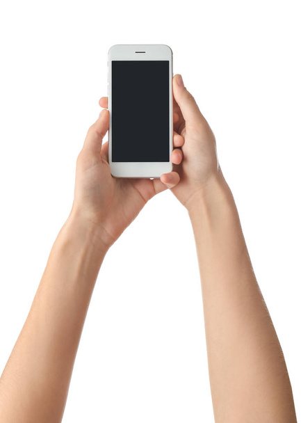Mladá žena držící mobilní telefon na bílém pozadí - Fotografie, Obrázek