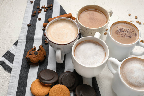 Many cups with tasty aromatic coffee and cookies on white table - Photo, Image