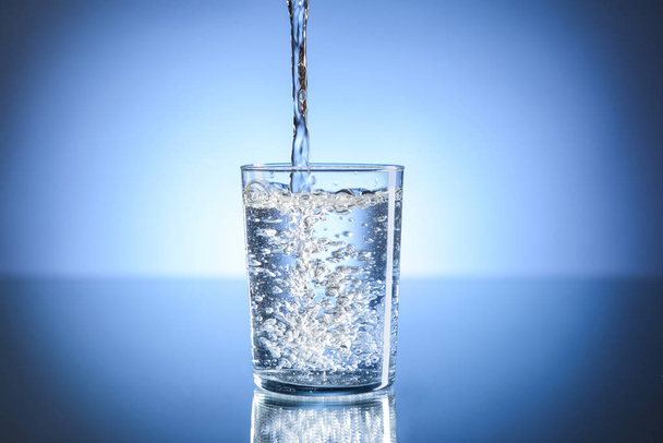 Заливка води в склянку на столі
 - Фото, зображення
