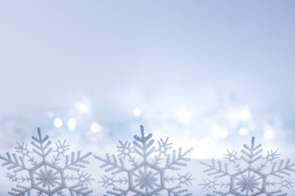 snowflakes row on blurry blue christmas lights background - Foto, imagen