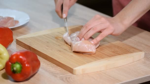 Chef woman cuts chicken at the kitchen. - Footage, Video