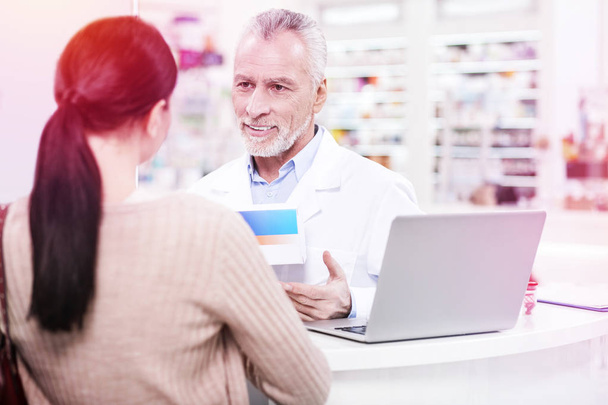 Positive senior pharmacist explaining an effect of prescription to a consumer - Фото, зображення