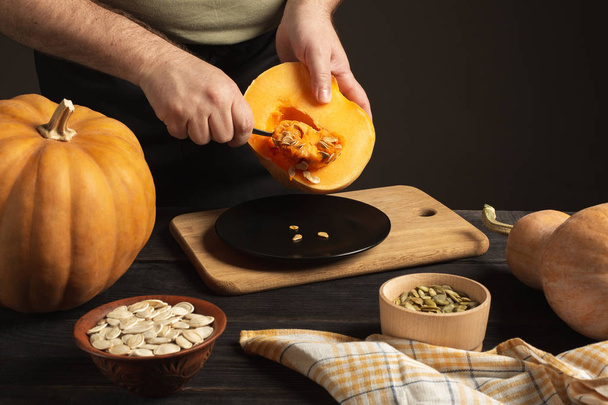 The cook separates the grain from the pumpkin cut in half. - Photo, Image