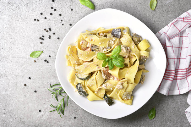 Delicious pasta dish with ricotta sauce and fresh herbs. Tagliatelle noodles on a white plate, italian cuisine. Top view or high angle shot with copy space. - Photo, image