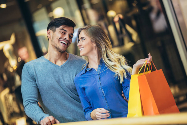 Happy young couple shopping and holding bags - Foto, Imagen