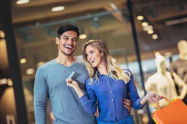 Ritratto di una coppia felice che mostra la nuova carta di credito al centro commerciale
 - Foto, immagini