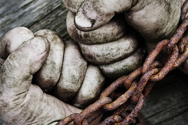 Výkonné špinavé mužské ruce zaťaté v pěst zřetězené s rezavý řetěz. - Fotografie, Obrázek