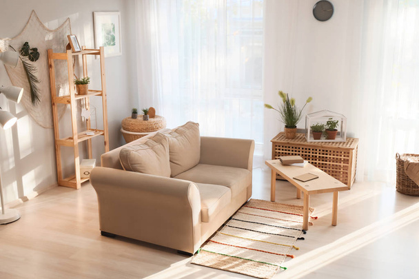 Interior da sala de estar em estilo ecológico com sofá confortável e plantas verdes
 - Foto, Imagem