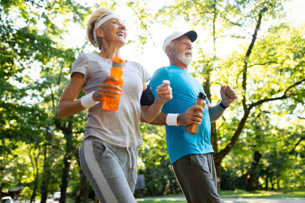 Fitness, sport, people, exercising and lifestyle concept - mature couple running - Foto, Imagem