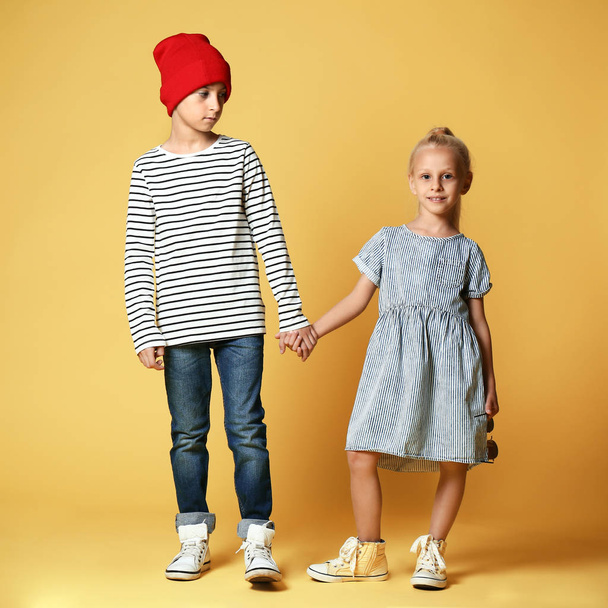Cute boy and girl in fashionable clothes on color background - Photo, Image
