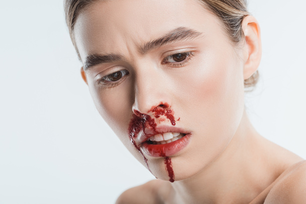 close up of sad wounded woman with blood in face after domestic violence isolated on white - Fotografie, Obrázek