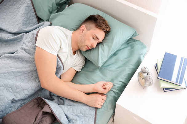 Handsome man sleeping in bed at home - Foto, afbeelding
