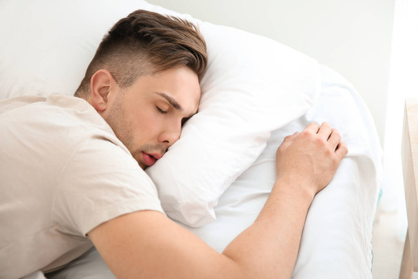 Hombre guapo durmiendo en la cama en casa
 - Foto, imagen
