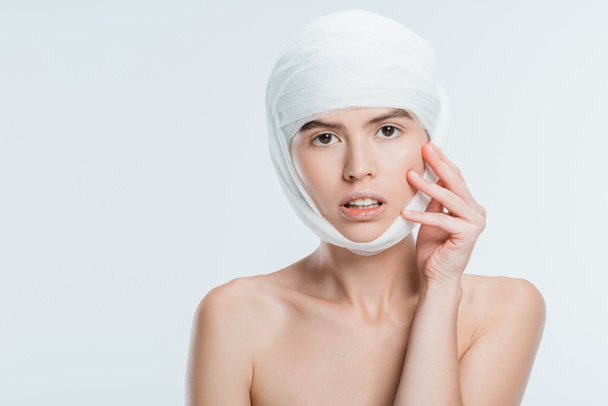 nude woman with bandages on head after plastic surgery isolated on white - Fotó, kép