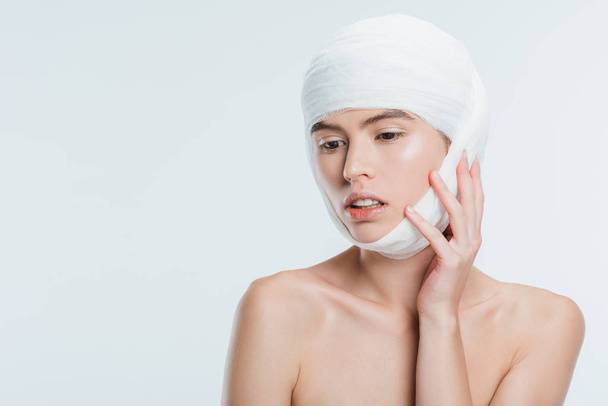 nude woman with bandages on head after plastic surgery isolated on white - Foto, Bild