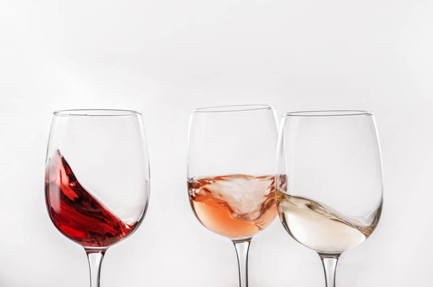 Gläser mit verschiedenen Weinen auf weißem Hintergrund - Foto, Bild