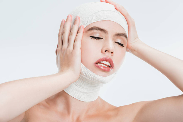 close up of adult beautiful woman after plastic surgery touching head isolated on white - Valokuva, kuva