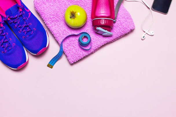 Concept de fitness avec baskets féminines rose ultra violet, bouteille d'eau, serviette, smartphone, casque pomme sur fond rose pastel plat vue sur le dessus. Chaussures de sport
 - Photo, image