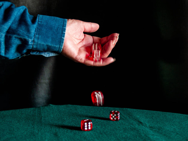 The hand of a person throwing the dice on a green carpet - Photo, Image