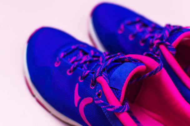 Ultra azul violeta rosa sapatilhas femininas no fundo rosa pastel flat lay vista superior com foco seletivo espaço de cópia. Sapatos de esportes, aptidão, conceito de treinamento diário de vida saudável
. - Foto, Imagem