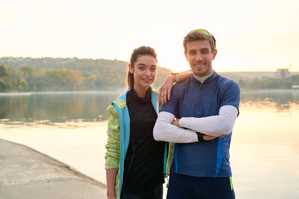 Sport motivation and healthy fitness lifestyle. Young couple of runners resting during outdoor morning workout. - Photo, Image