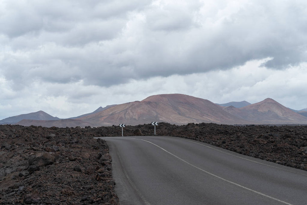 Road crossing volcanic terrain, Lanzarote Island, Canary Islands, Spain - Photo, Image