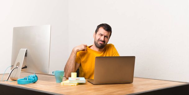 Praca z laptot w biurze z wyrażenie zmęczony i chory człowiek - Zdjęcie, obraz