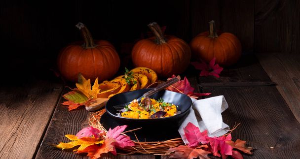 plato con calabaza vegetariana felicitada con grañones de cebada y ciruelas con tomillo y hojas de otoño sobre fondo
  - Foto, Imagen