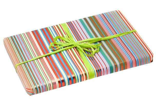 Geschenkbox in gestreiftem buntem Papier mit grüner Schleife verpackt. - Foto, Bild