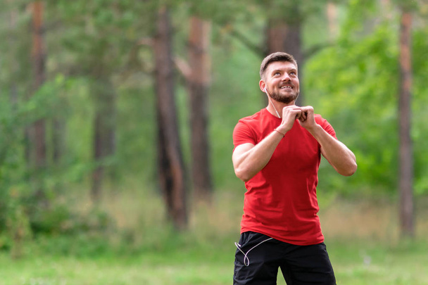 Miehen juoksukoulutus. Miesurheilija venyttelee lihaksia puistossa. Terveet, kunto, hyvinvointi elämäntapa. Urheilu, sydän, harjoitus käsite - Valokuva, kuva