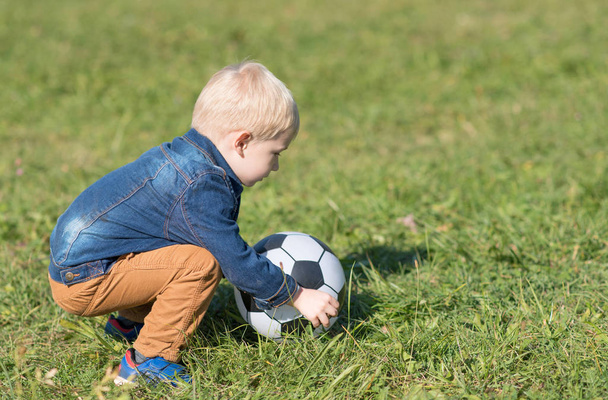 Adorable little child play football in the park - 写真・画像