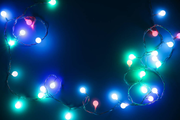 Christmas lights on dark background, top view - Photo, Image