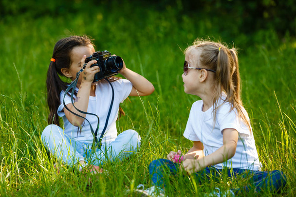 Deux enfants fille tenant la caméra et prendre des photos dans le parc vert
 - Photo, image
