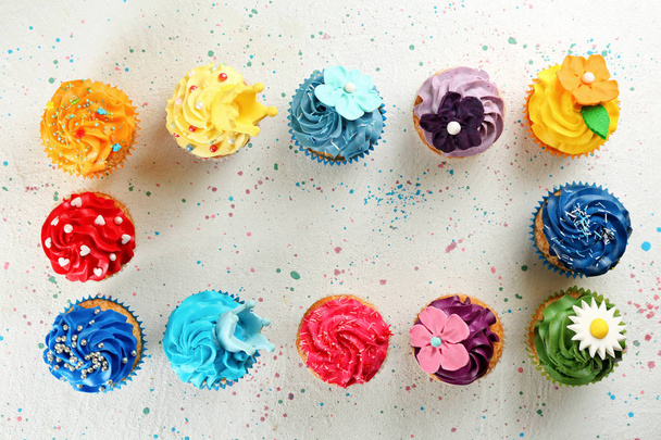 Frame made of tasty cupcakes on light background - Photo, Image