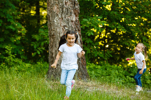 Ευτυχισμένα παιδιά που τρέχουν σε πράσινο καλοκαιρινό πάρκο - Φωτογραφία, εικόνα