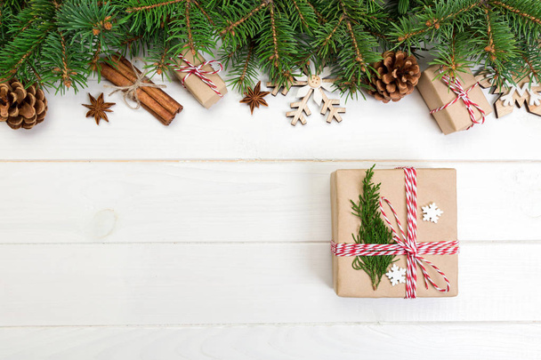 Christmas background with fir tree and gift box on wooden table. Top view with copy space for your design. - 写真・画像