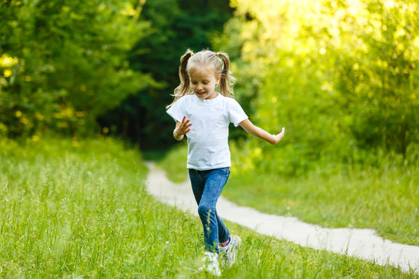 маленька дівчинка в зеленій сукні, що бігає в парку
 - Фото, зображення