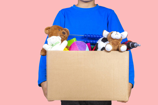 Adomány fogalma. Gyerek gazdaság adományoz box ruhák, könyvek és játékok - Fotó, kép
